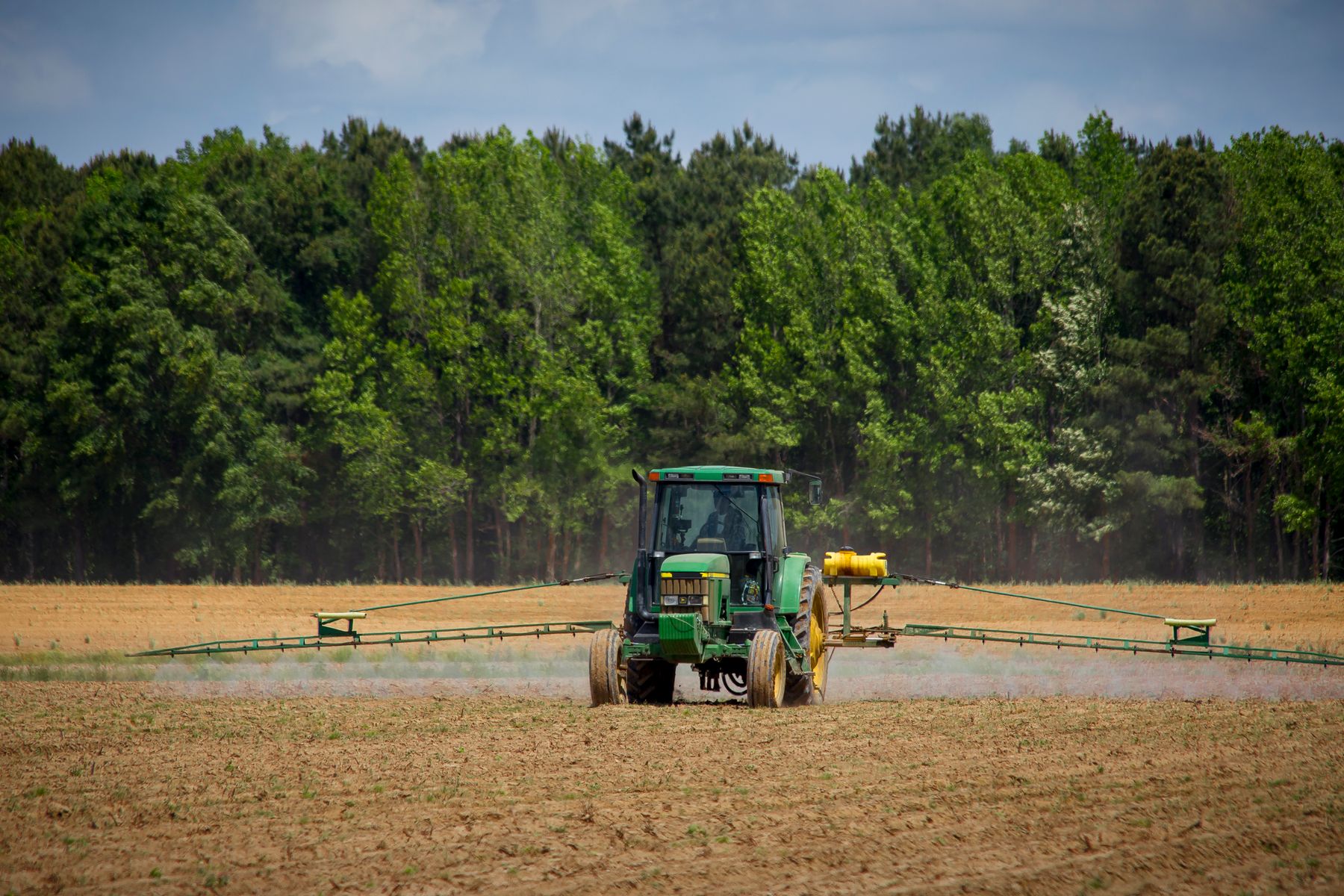 Trator em operação de pulverização agrícola